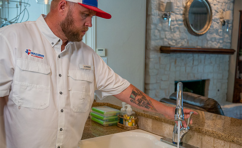 Garland plumber fixing kitchen faucet